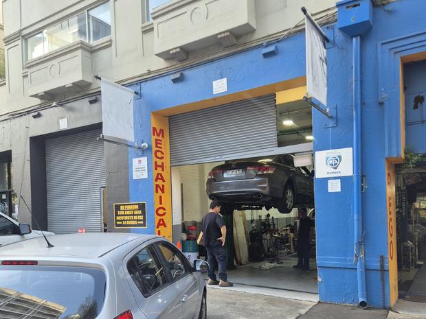 The mechanical workshop entrance at Shops 5 & 6, 342-344 Bourke Street, Surry Hills, with a car on the hoist